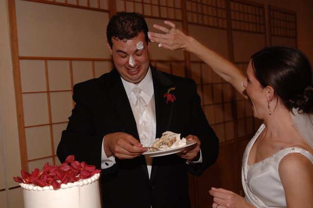 Playful Wedding Cake Smashing Moment at Reception