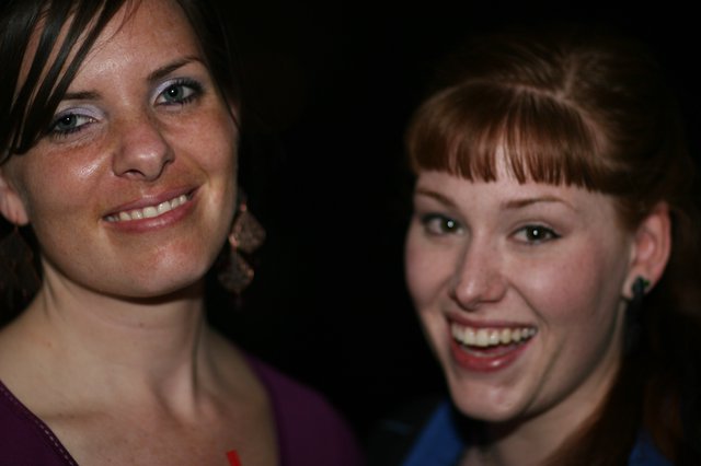 Two Friends Laughing Together at a Nighttime Event