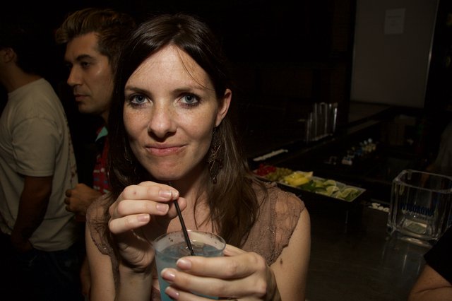 Woman at Bar Smiling with Cocktail Drink