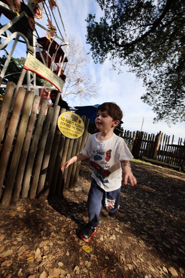 Young Boy Running Through Playground on Autumn Day