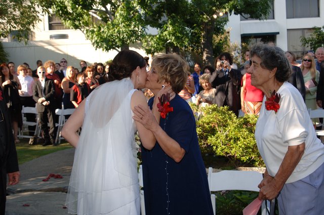 Bride Receives Tender Kiss at Outdoor Wedding Ceremony