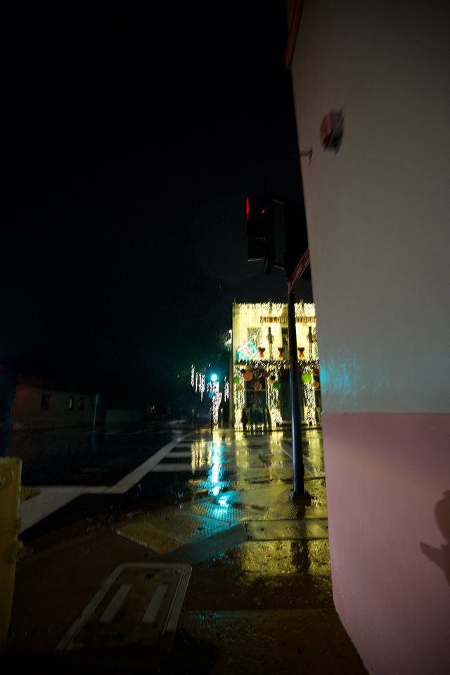 Wet Night Street with Festive Lights and Blue Glow