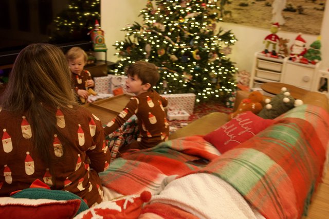 Christmas Morning Family Gathering Around Illuminated Tree
