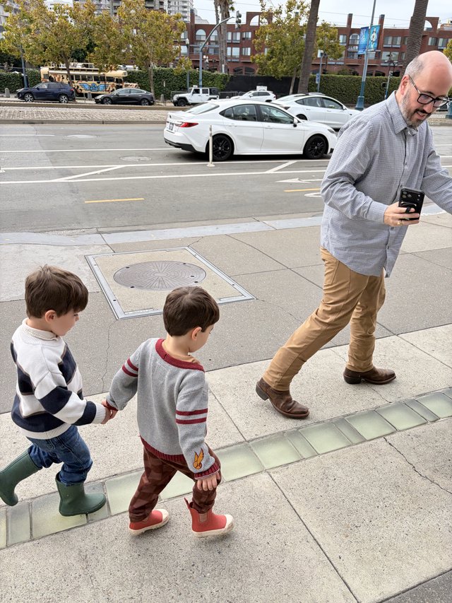 Father and Sons Walking Through Urban Sidewalk