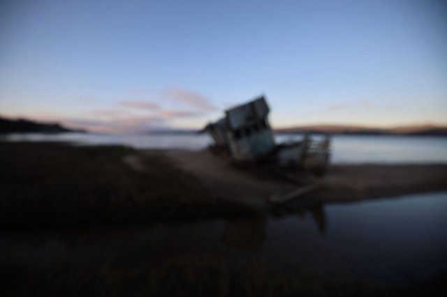 Shipwreck at Twilight on Coastal Beach
