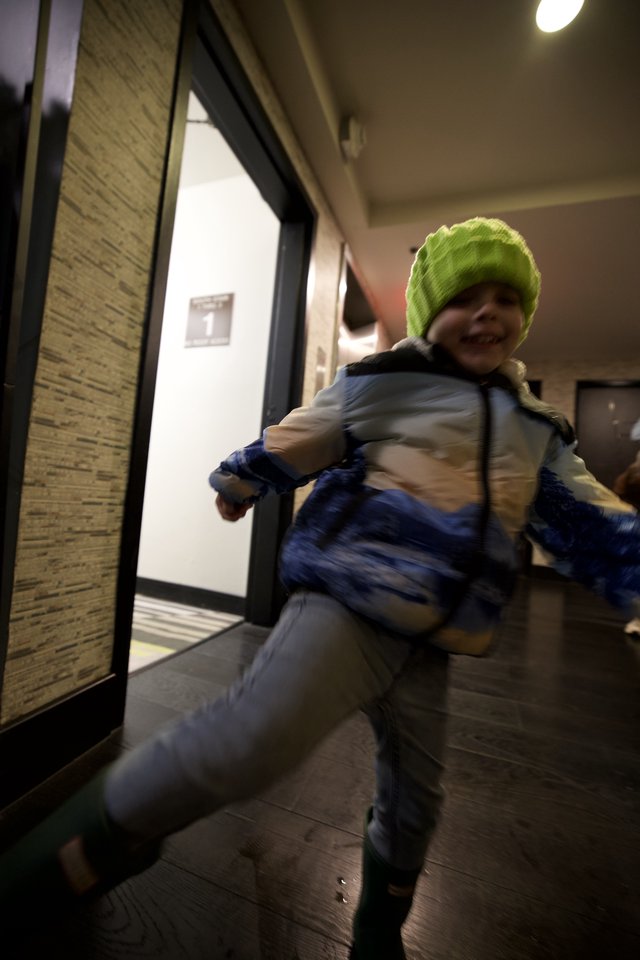 Young Child Running Through Modern Building Hallway