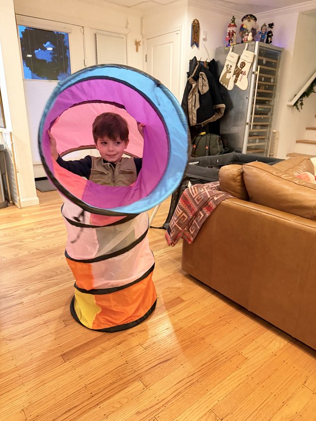 Child Playing in Colorful Pop-Up Tunnel at Home