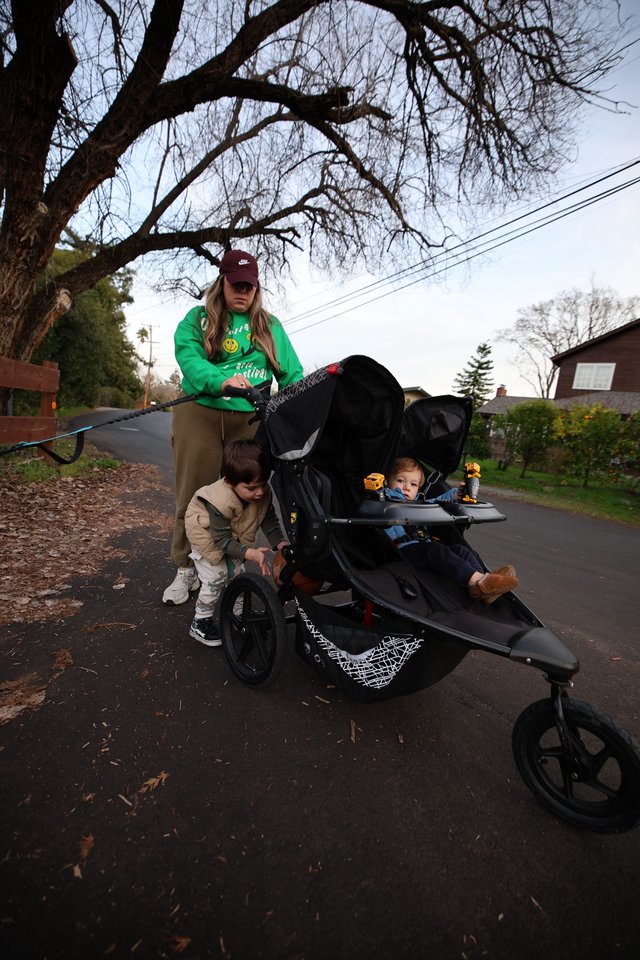 Mother with Two Young Children in Double Stroller on Winter Walk