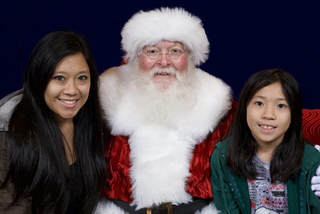 Santa Claus Brings Smiles to Two Girls at APC Xmas Party