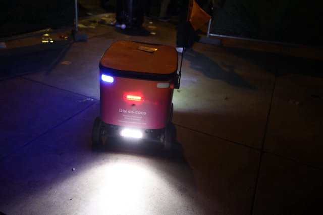 Coco Delivery Robot Glows on Nighttime Sidewalk