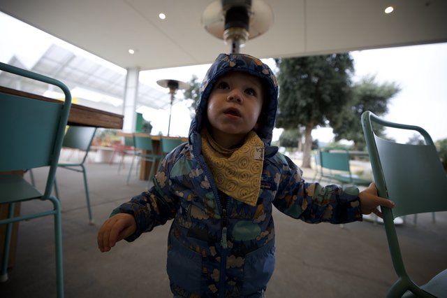 Toddler's Wonder Under Heat Lamp at Outdoor Café