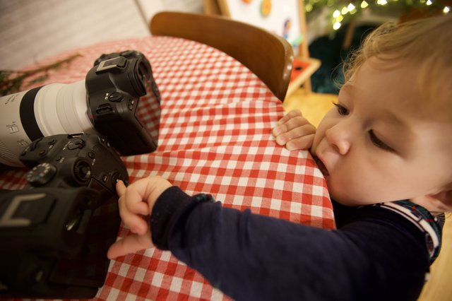 Curious Toddler Exploring Professional Camera Equipment