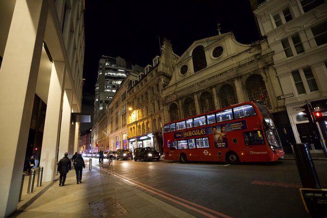 Red Double-Decker Bus on London Street at Night