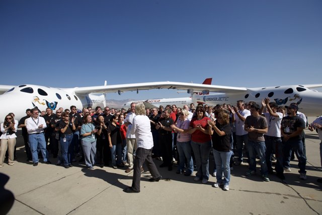 A Group of People Stand around a Small Airplane
