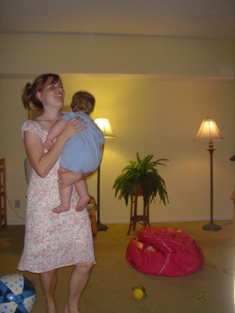 Joyful Mother Lifting Laughing Baby in Living Room