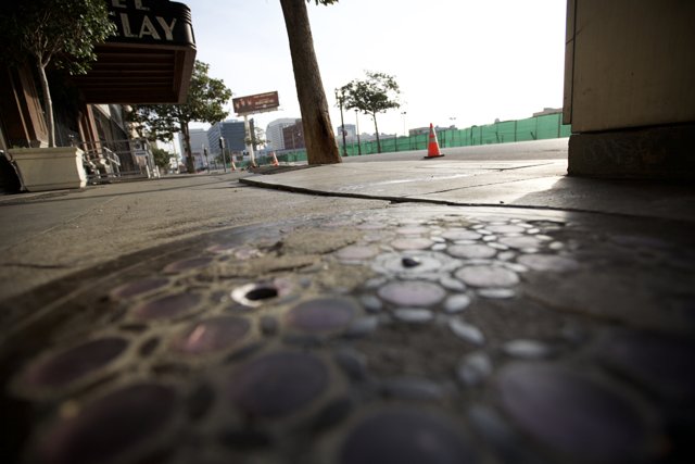 Manhole Cover on City Sidewalk