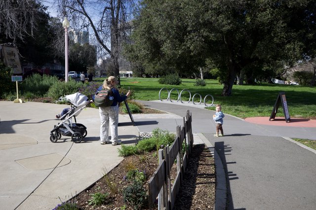Young Family Explores Sunny Urban Park Pathway