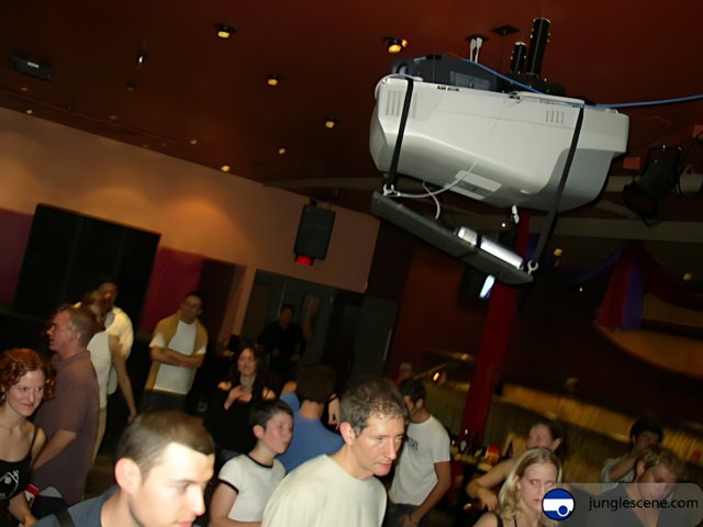Nightclub Crowd Gathers Around Projector