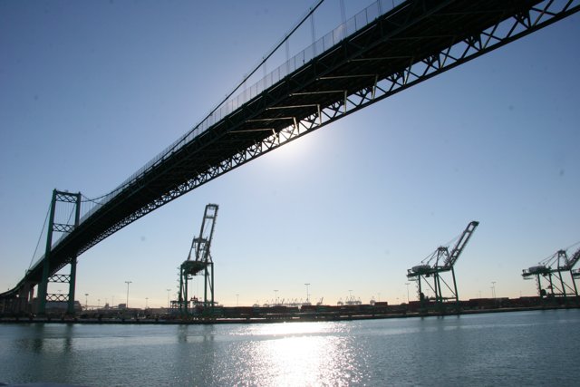 Arch Bridge over Lake with Cranes and Ships