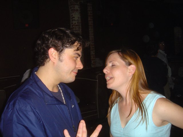Two Friends in Animated Conversation at Nightclub
