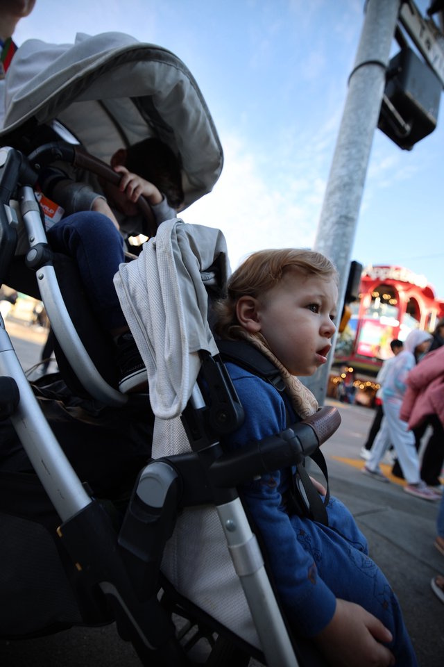 Young Child Watches Carnival Lights at Twilight Fair