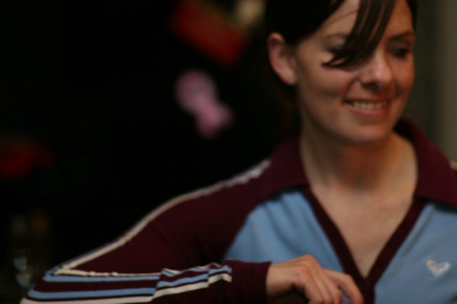 Smiling Woman in Burgundy Track Jacket Indoors