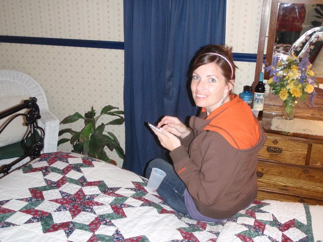 Woman Texting on Patchwork Quilt in Cozy Bedroom