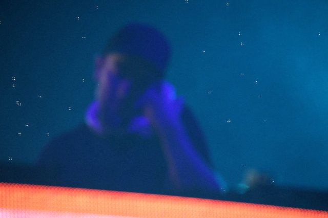 Silhouetted DJ Performs Under Electric Blue Stage Lights