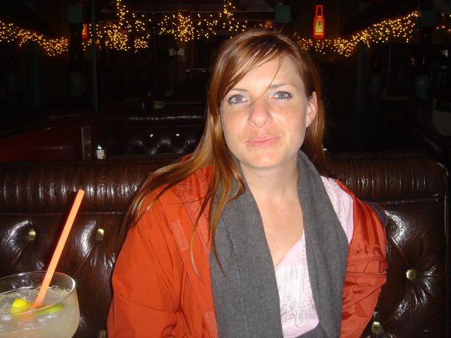 Woman Relaxing in Dimly Lit Bar Booth