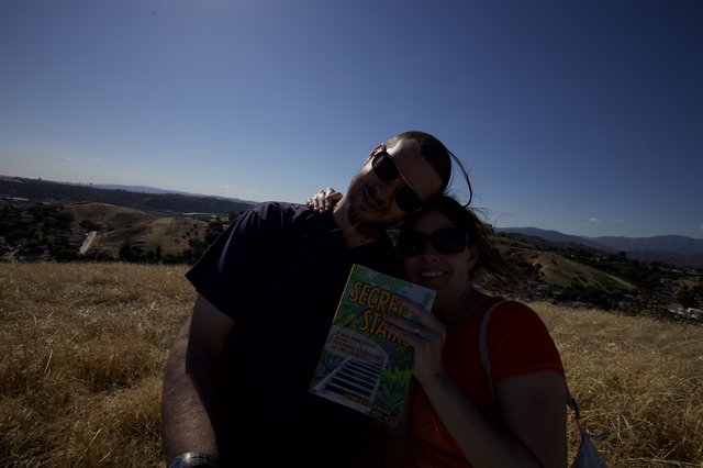 Couple Poses with Secret Stairs Book on LA Hilltop