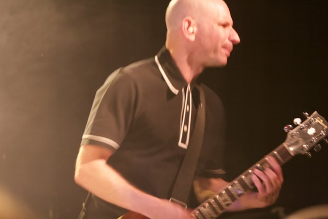 Bald Man Rocks the Electric Guitar on Stage