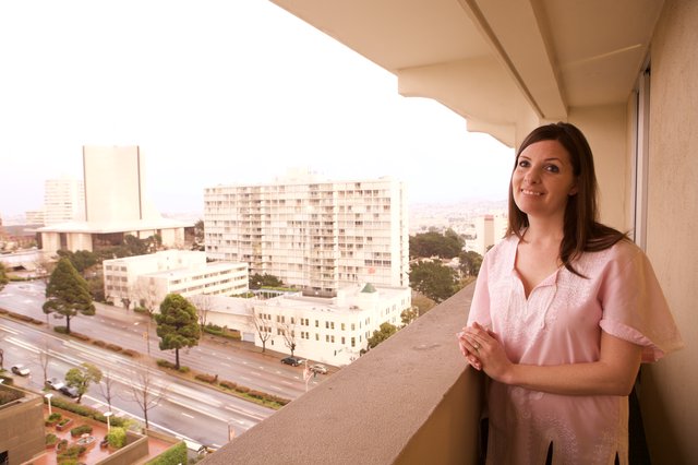 Woman Smiling on Hotel Balcony Overlooking San Francisco