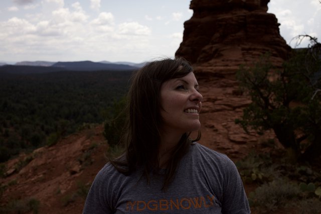 Woman Smiling Atop Red Rock Canyon Overlook