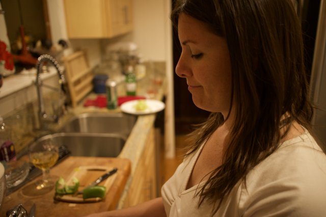 Woman Chopping Vegetables in a Cozy Kitchen