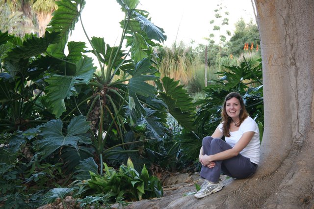 Young Woman Smiling Beside Tropical Garden Tree