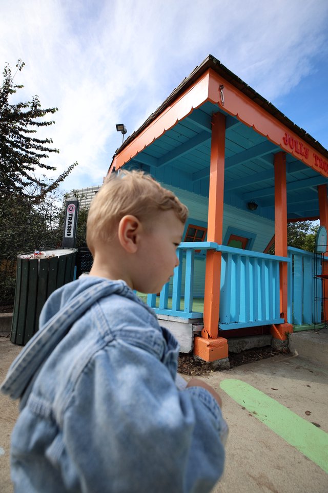 Child Gazes at Vibrant Turquoise and Orange Playhouse