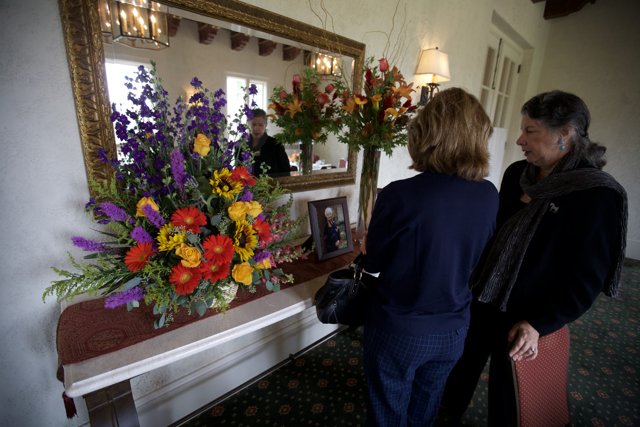 Women Admiring Flower Arrangements in Memory of Grandma