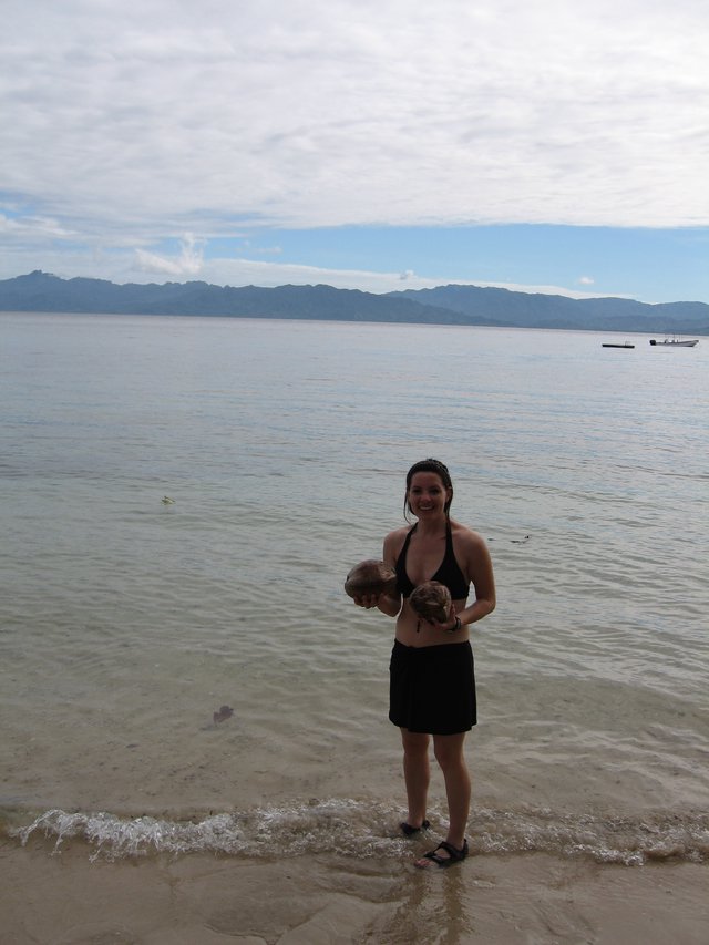 Woman Holding Coconuts on Fijian Beach Shore