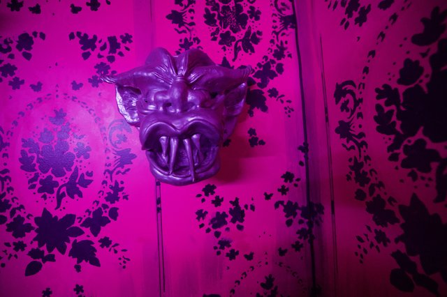 Ornate Purple Dragon Mask on Vibrant Floral Wallpaper
