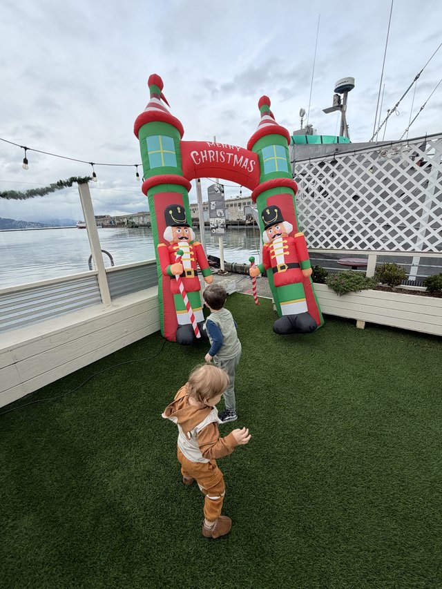 Children Enjoying Inflatable Christmas Display by the Water