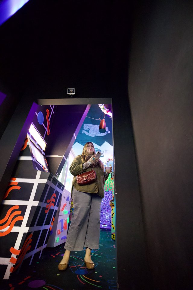 Woman in Colorful Installation Art Space with Mirror