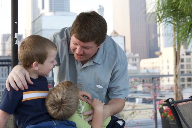 Father Shares a Tender Moment with Two Sons