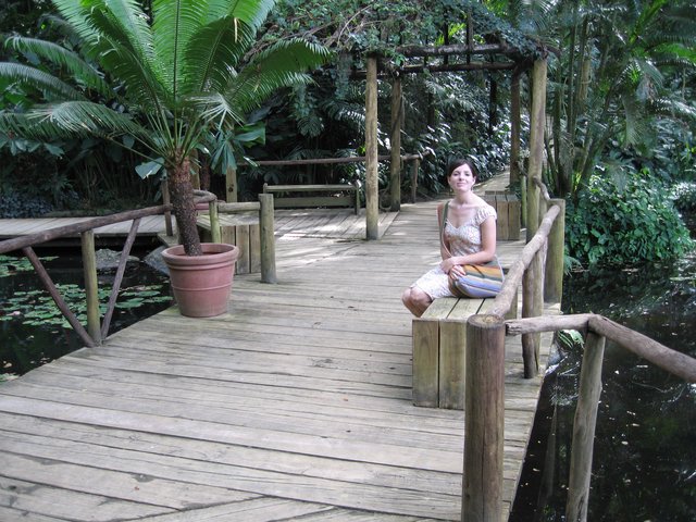 Woman Resting on Wooden Deck in Lush Garden