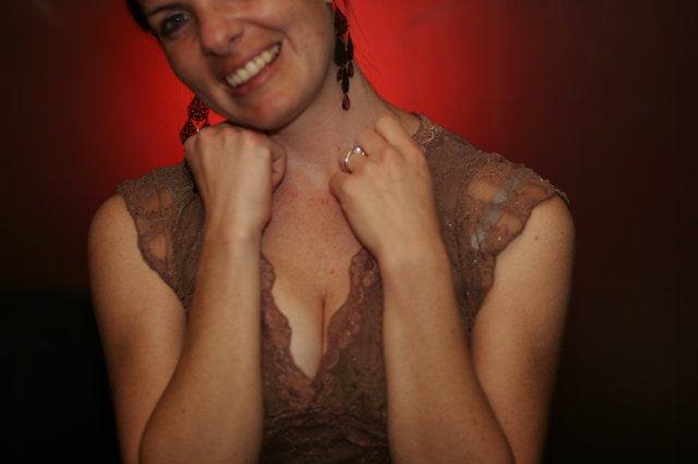 Smiling Woman in Lace Dress Against Red Background