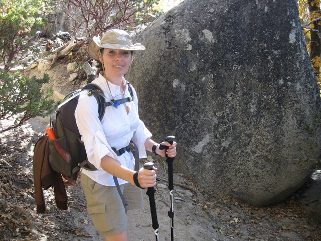 Hiker Pauses Beside Granite Boulder on Mountain Trail