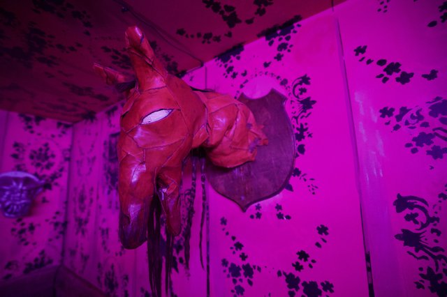 Red Sculptural Horse Head in Magenta-Lit Gallery