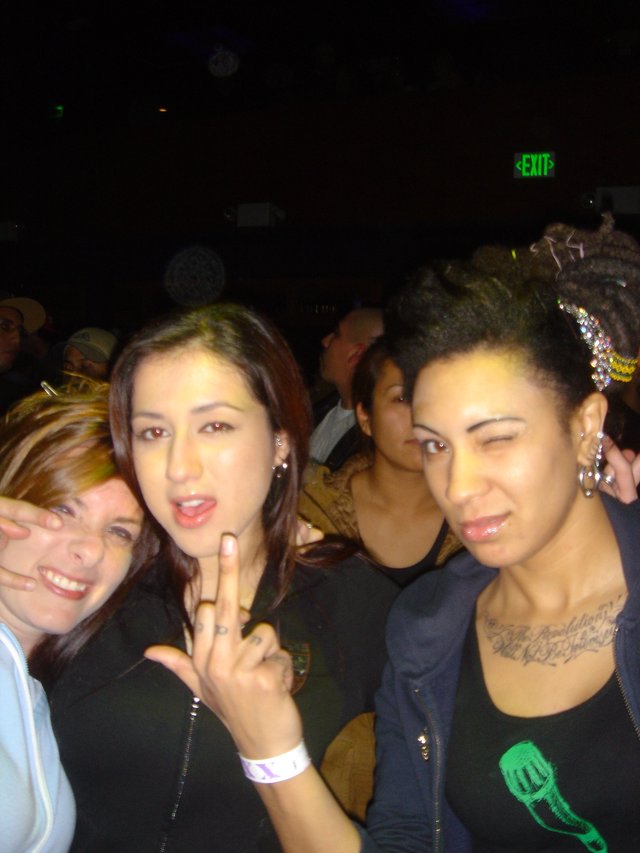 Three Friends Posing at a Dark Concert Venue