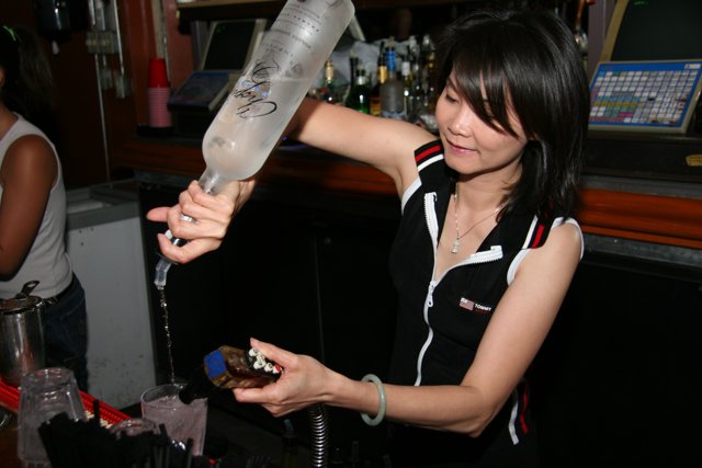 Bartender pouring drinks for a woman at the pub