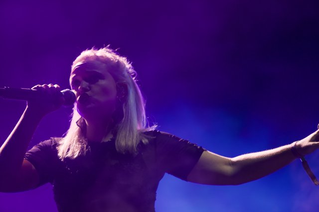Rocking the Stage: Blonde-haired Singer Performs Solo