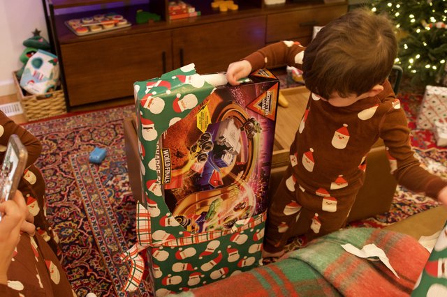 Child Unwrapping Wolverines Toy on Christmas Morning